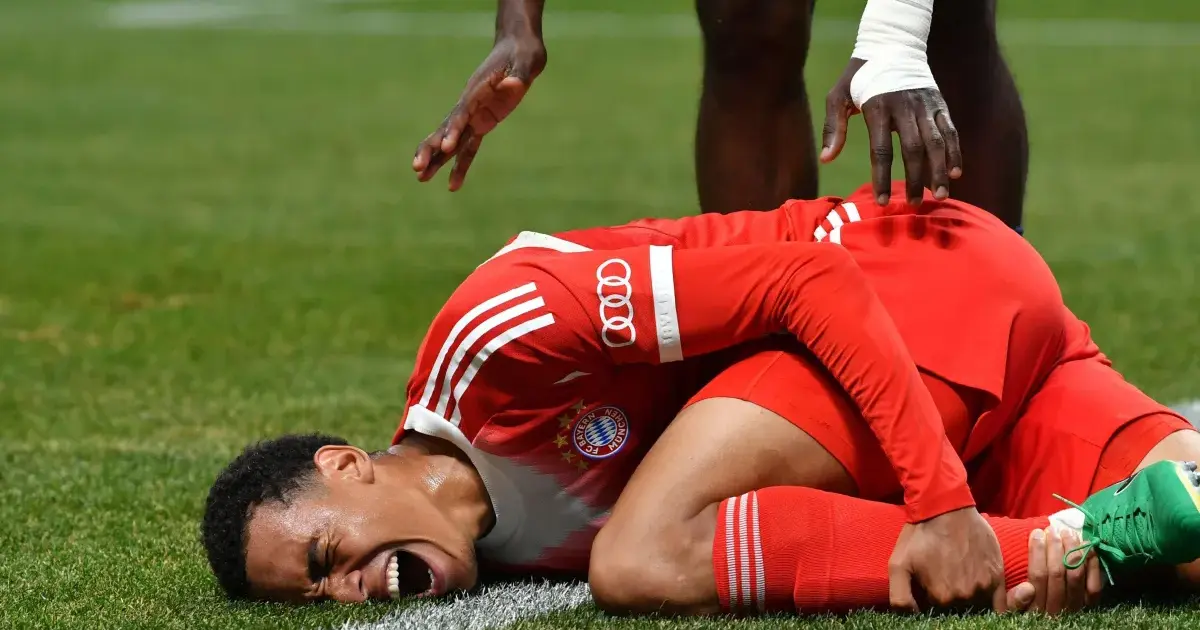 Estádio de futebol cheio de adeptos durante um jogo noturno