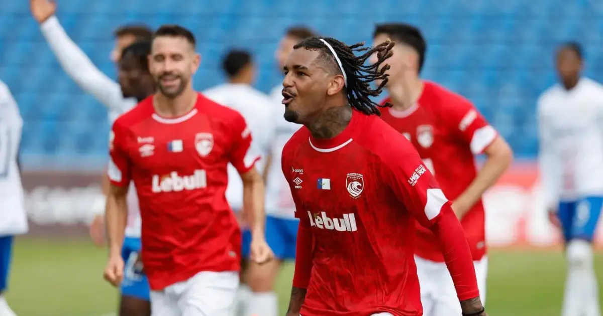 Jogadores em disputa pela bola num jogo de futebol